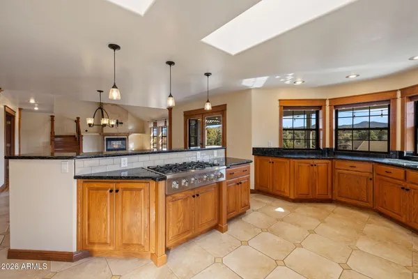 a large kitchen with stainless steel appliances granite countertop a stove and a sink