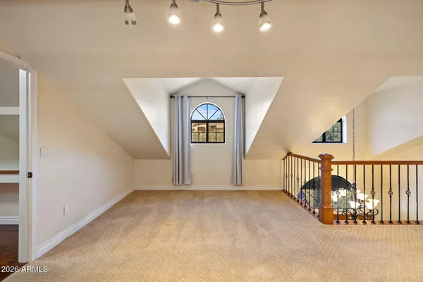 a view of an empty room with wooden floor and windows
