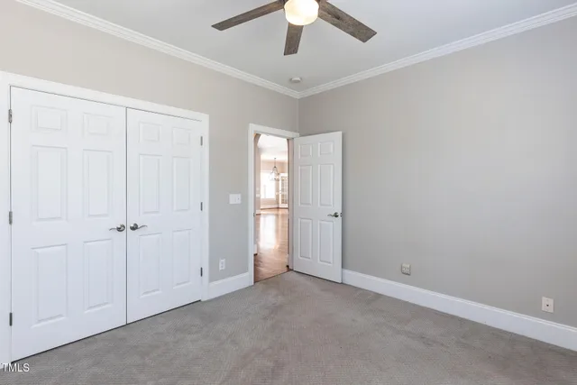 a view of an empty room and chandelier fan