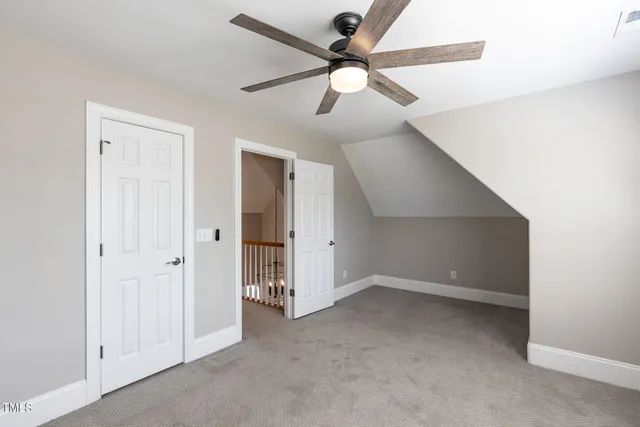 an empty room with ceiling fan and window