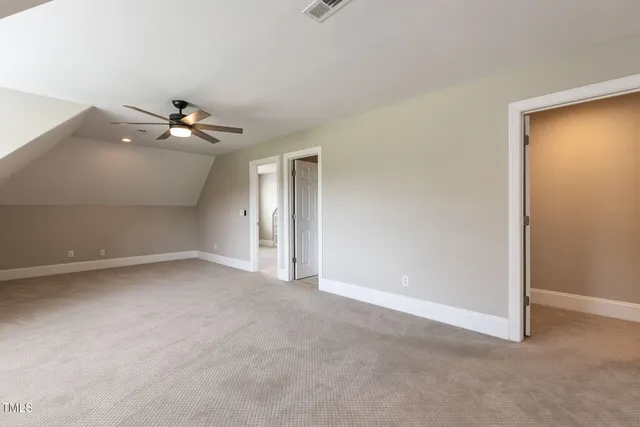 an empty room with a ceiling fan and a window