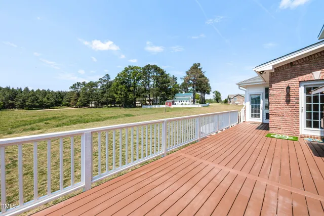 a view of a balcony with wooden floor and fence