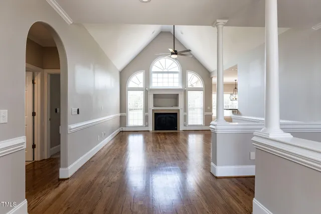 a view of a living room with a fireplace and wooden floor