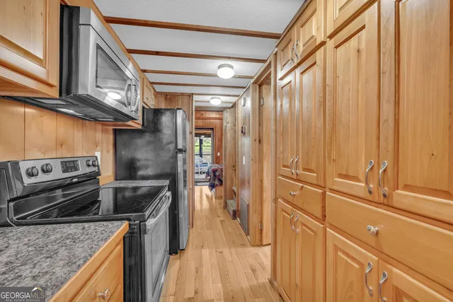 a view of a hallway with wooden floor and windows