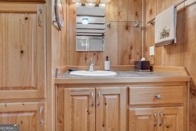 a bedroom with a bed a dresser and a shower