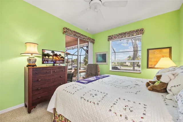 a bedroom with a bed and large windows