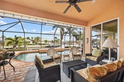 a view of a swimming pool with a lounge chairs in front of a house