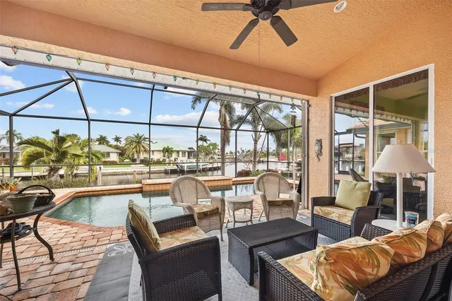 a view of a swimming pool with a lounge chairs in front of a house