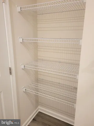a view of empty room with wooden floor and window