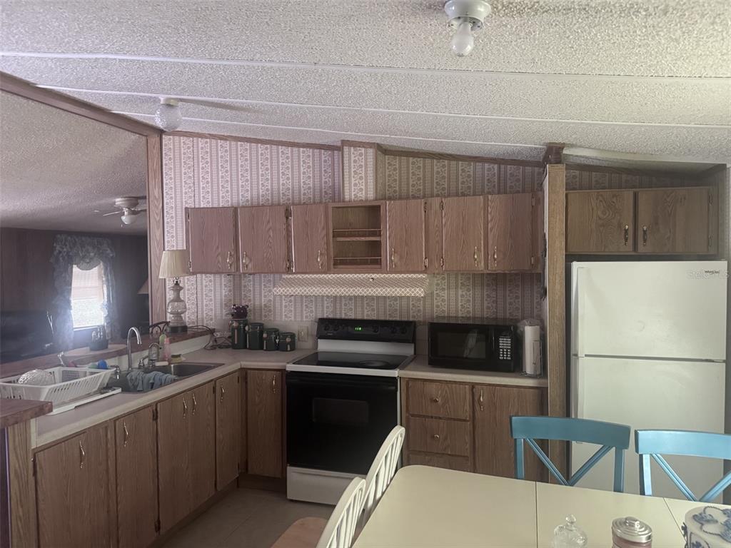 20050 Ruth Street Brooksville, FL 34601 - Photo 13 of 18 a kitchen with a sink a stove a refrigerator and cabinets