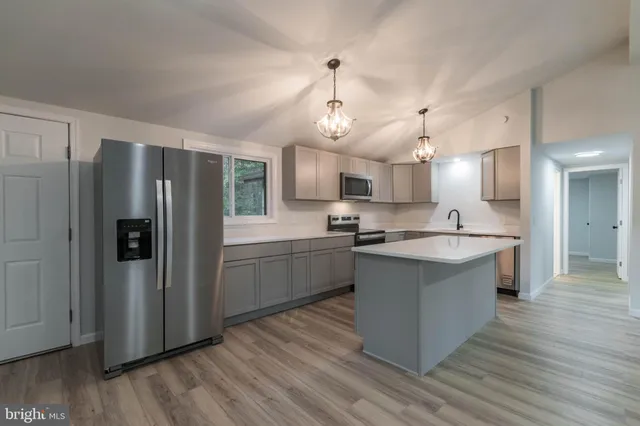 a view of a kitchen with a sink and dishwasher a refrigerator with wooden floor