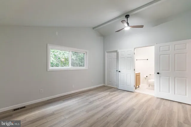 an aerial view of a house with yard and trees in the background