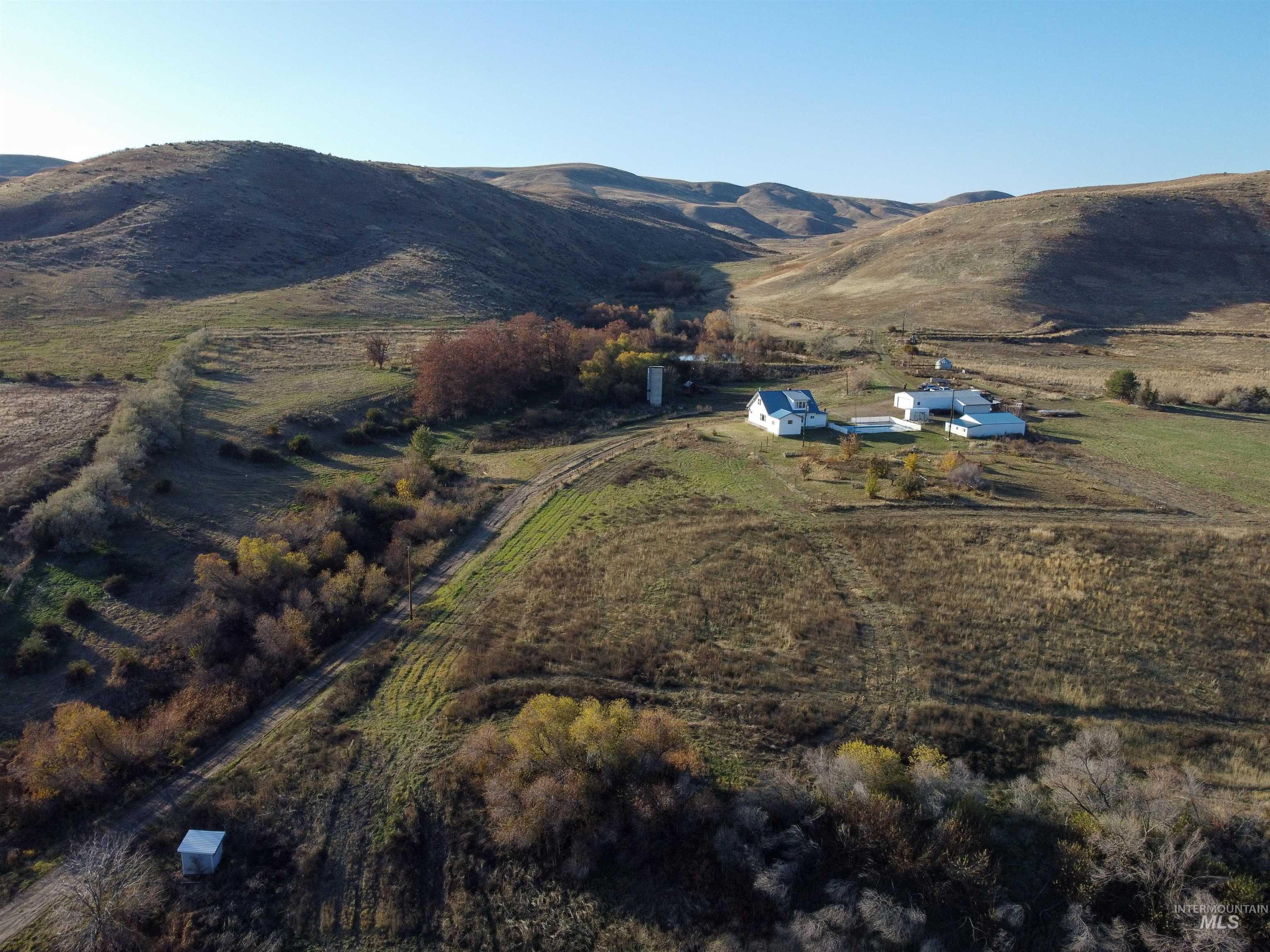 1854 Guilford Road Weiser, ID 83672 - Photo 19 of 33 Aerial view of property and surrounding area with a mountain backdrop and rural landscape