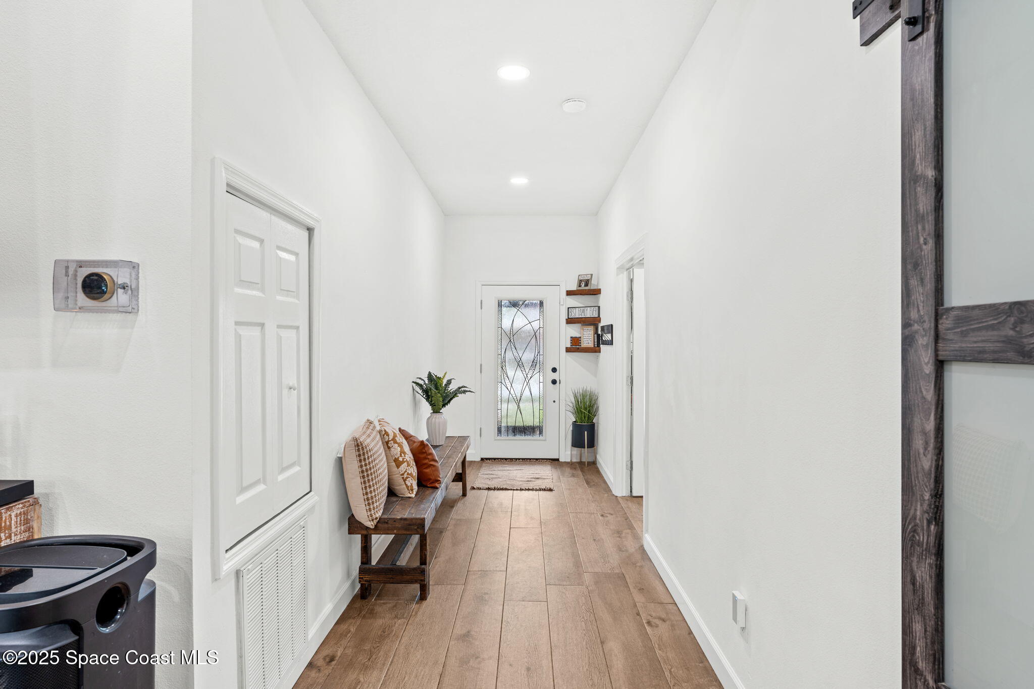 1292 Brumpton Place Rockledge, FL 32955 - Photo 3 of 69 a view of a hallway with wooden floor and a living room