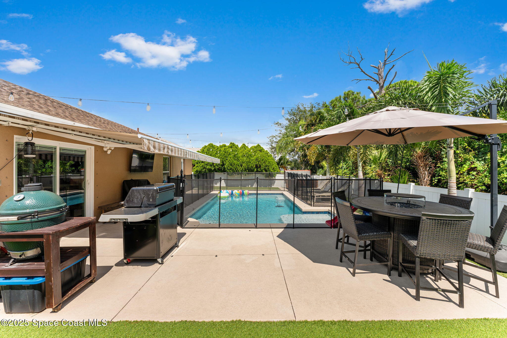 1292 Brumpton Place Rockledge, FL 32955 - Photo 33 of 69 a view of a patio with table and chairs under an umbrella with a small yard