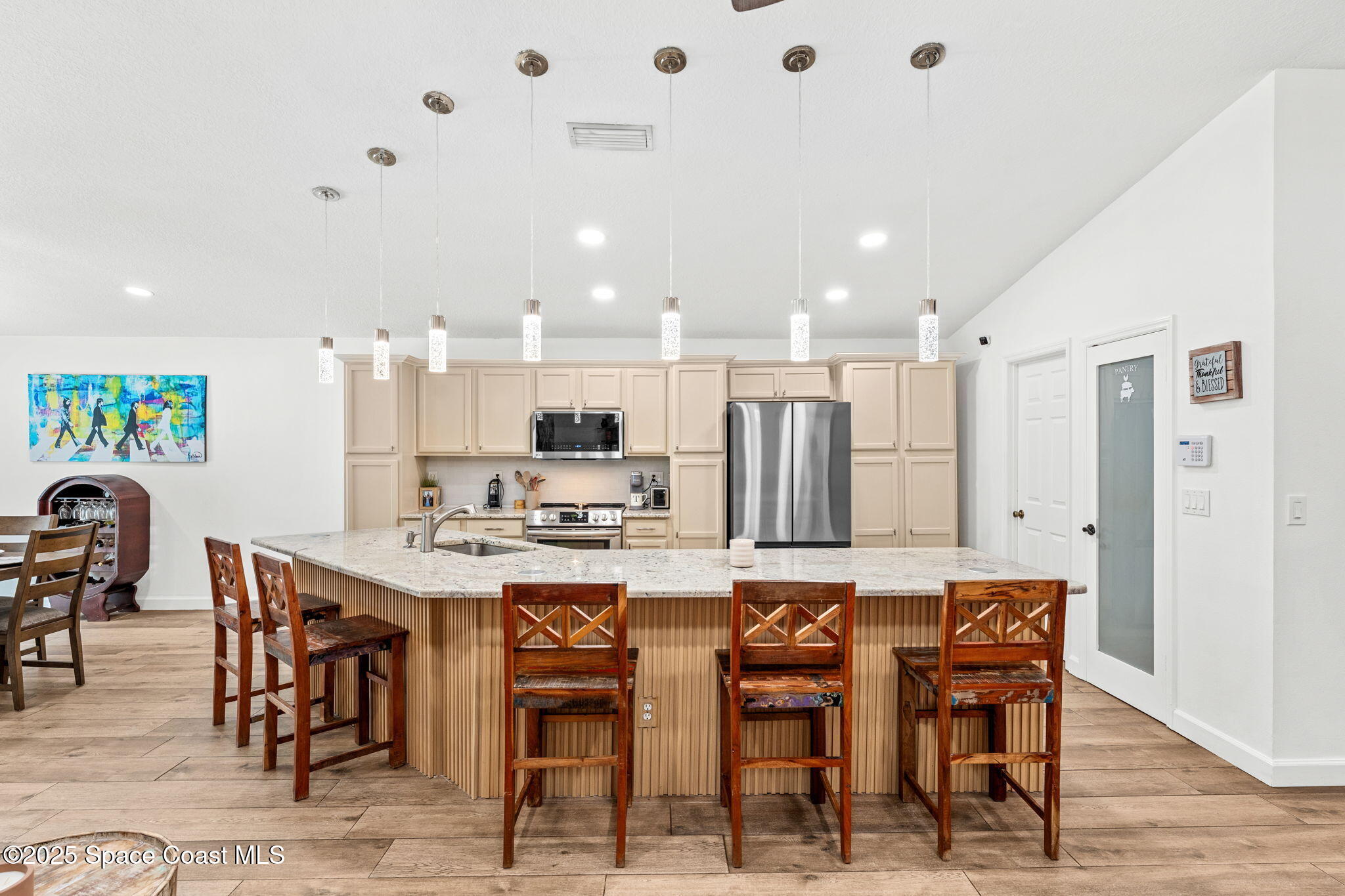1292 Brumpton Place Rockledge, FL 32955 - Photo 4 of 69 a kitchen with stainless steel appliances kitchen island granite countertop a table and chairs in it