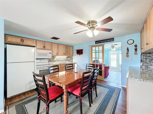 a dining room with furniture a chandelier and wooden floor
