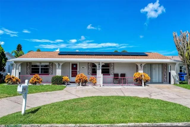 a front view of a house with garden and plants