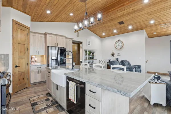 a kitchen with stainless steel appliances granite countertop a sink refrigerator and cabinets