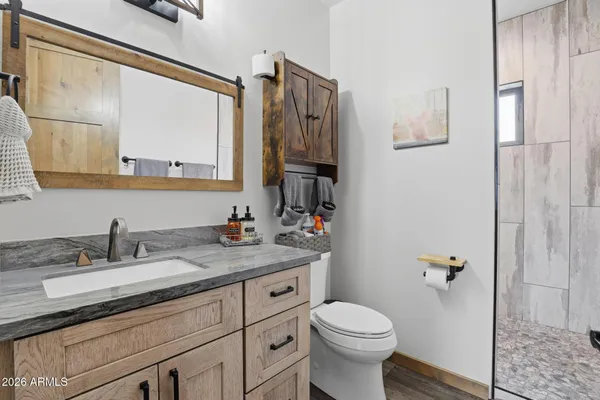 a bathroom with a granite countertop sink toilet and shower