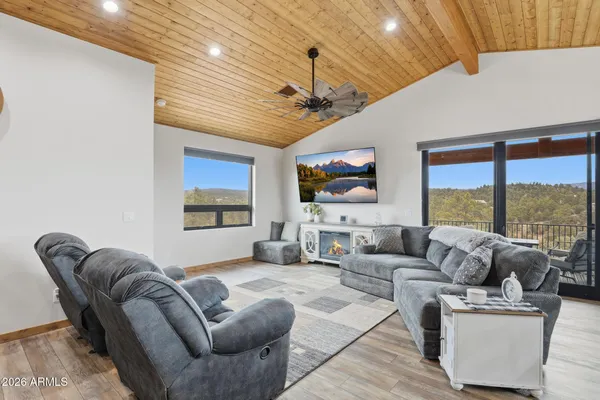 a living room with furniture ceiling fan and a flat screen tv
