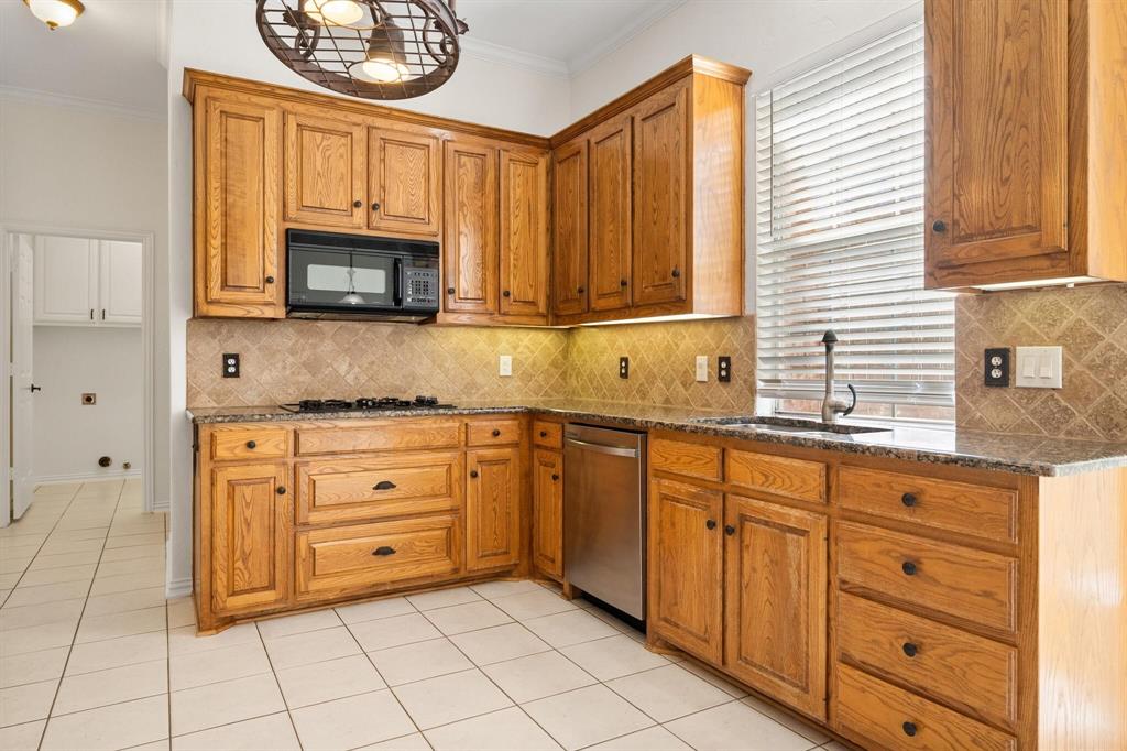 4512 Crown Ridge Drive Plano, TX 75024 - Photo 10 of 32 a kitchen with granite countertop a stove a sink and a microwave