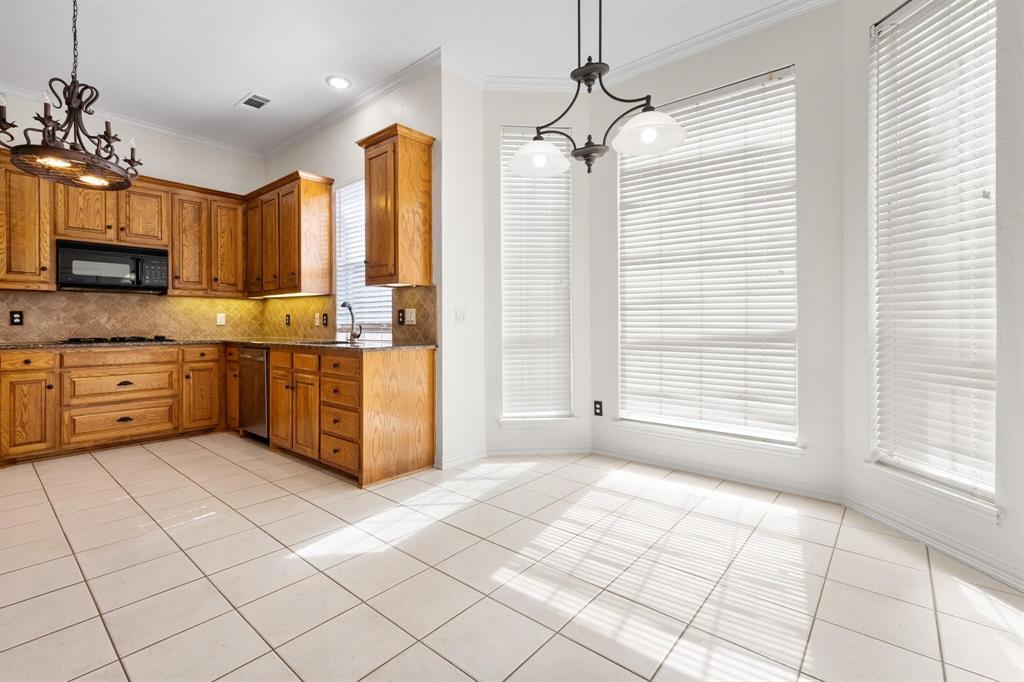 4512 Crown Ridge Drive Plano, TX 75024 - Photo 12 of 32 a kitchen with stainless steel appliances granite countertop a stove a sink and a refrigerator