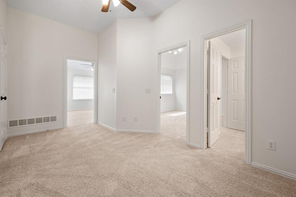 4512 Crown Ridge Drive Plano, TX 75024 - Photo 21 of 32 an empty room with closet area chandelier fan and windows