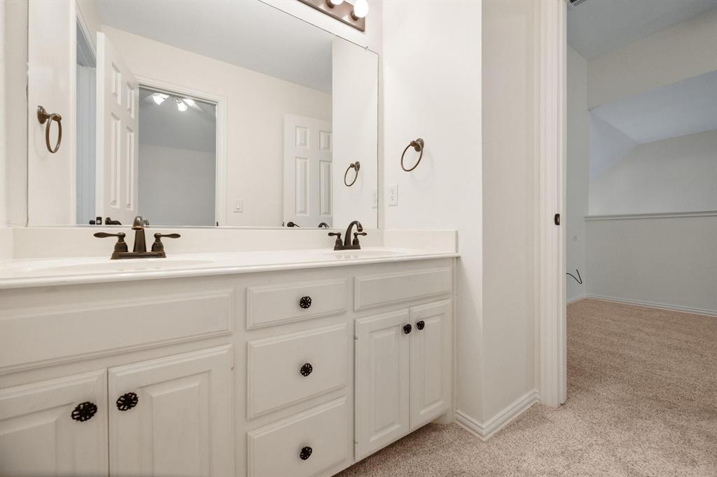 4512 Crown Ridge Drive Plano, TX 75024 - Photo 23 of 32 a bathroom with double vanity sink and mirror