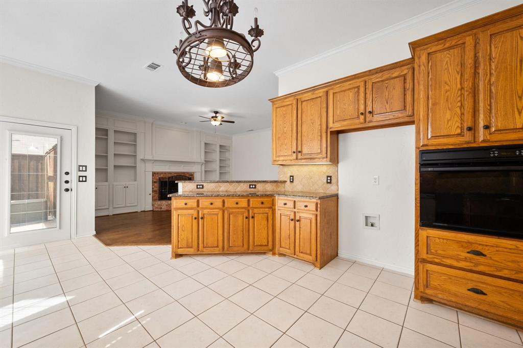 4512 Crown Ridge Drive Plano, TX 75024 - Photo 32 of 32 a kitchen with granite countertop a refrigerator and a stove top oven