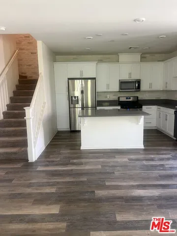 a view of kitchen with wooden floor and electronic appliances