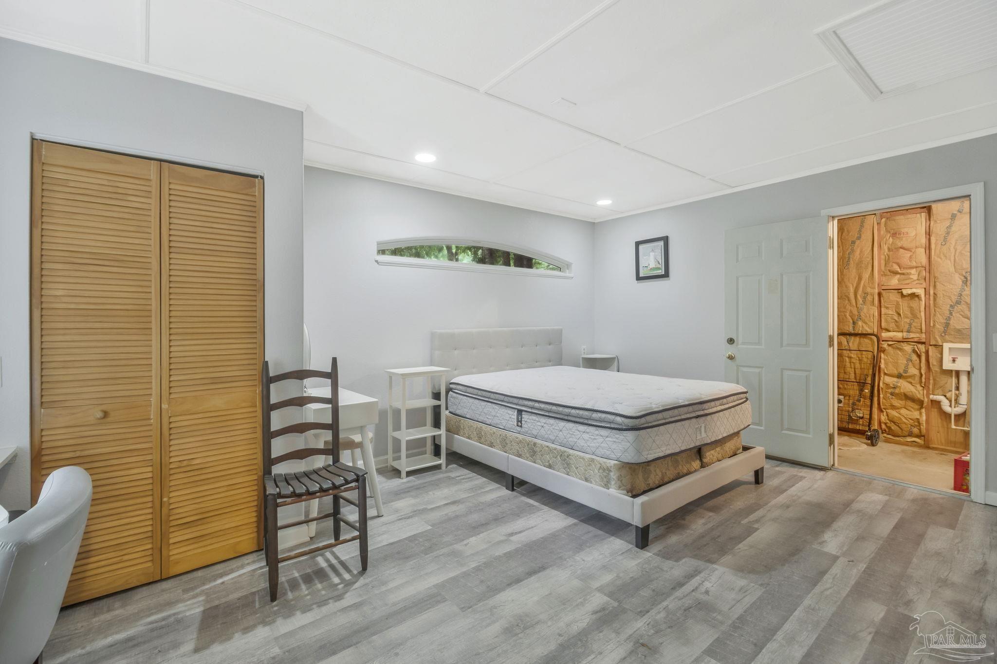 10290 West Lake Road Milton, FL 32583 - Photo 4 of 53 a spacious bedroom with a bed and wooden floor