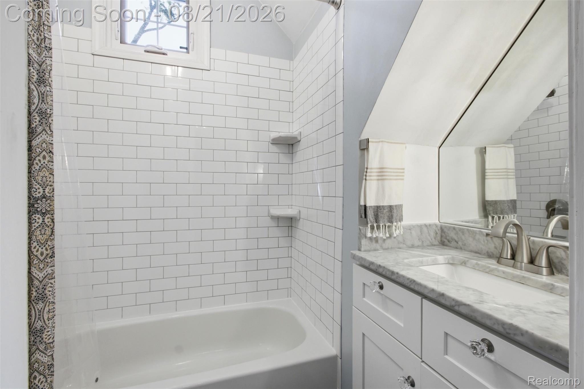 1383 Princeton Road Berkley, MI 48072 - Photo 13 of 28 White subway tile shower surround, built-in bathtub, window with white trim, single vanity with stone countertop, and brushed nickel faucet