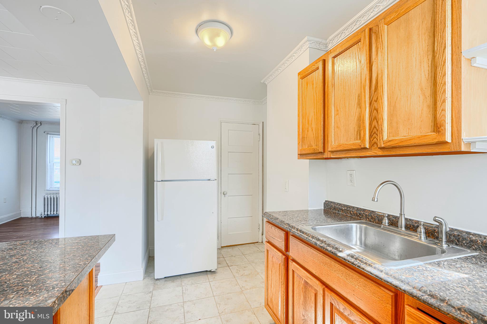 30 Portship Road Baltimore, MD 21222 - Photo 11 of 33 a kitchen with granite countertop a sink and a refrigerator
