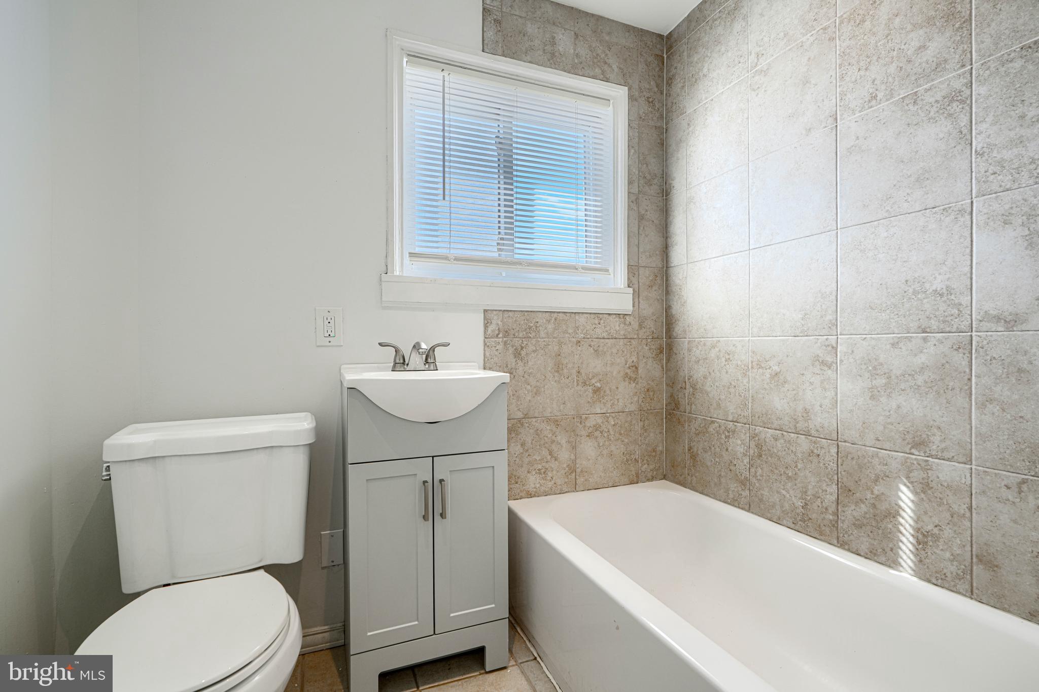 30 Portship Road Baltimore, MD 21222 - Photo 19 of 33 a white toilet sitting next to a white bath tub sitting next to a white sink