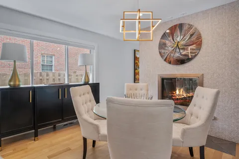 a living room with furniture a fireplace and a large window