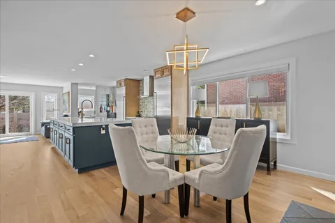 a dining room with furniture a chandelier and wooden floor