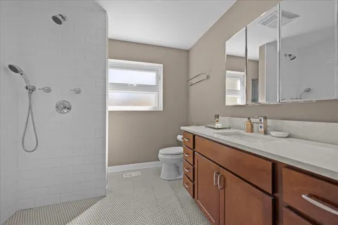 a bathroom with a granite countertop sink a toilet and shower