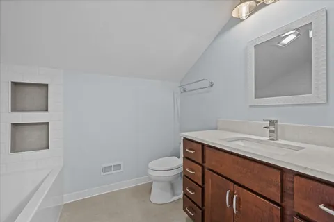 a bathroom with a granite countertop sink a toilet and a mirror