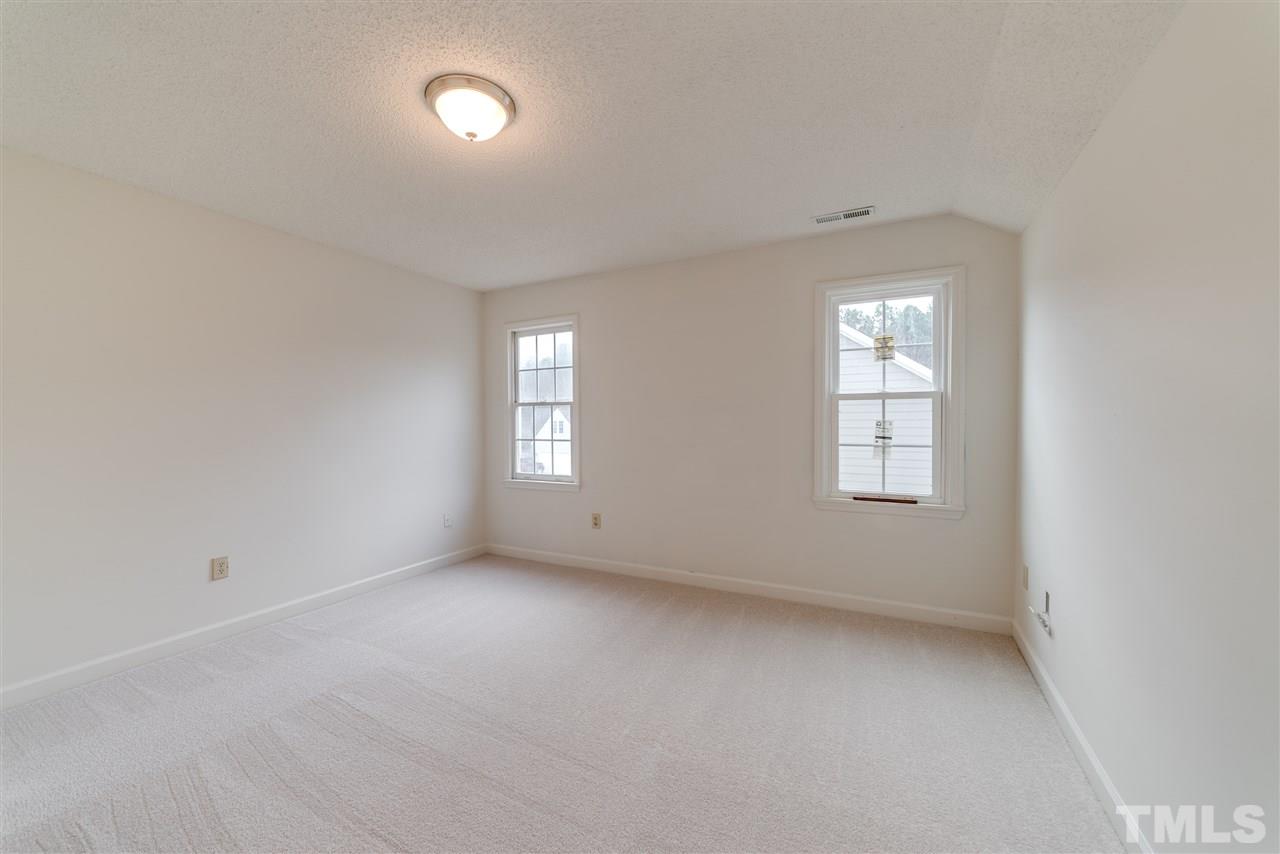 4213 Knightsbridge Way Raleigh, NC 27604 - Photo 17 of 23 an empty room with windows and chandelier fan