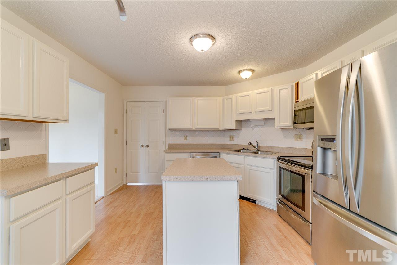 4213 Knightsbridge Way Raleigh, NC 27604 - Photo 9 of 23 a kitchen with stainless steel appliances granite countertop a refrigerator a stove top oven a sink and dishwasher