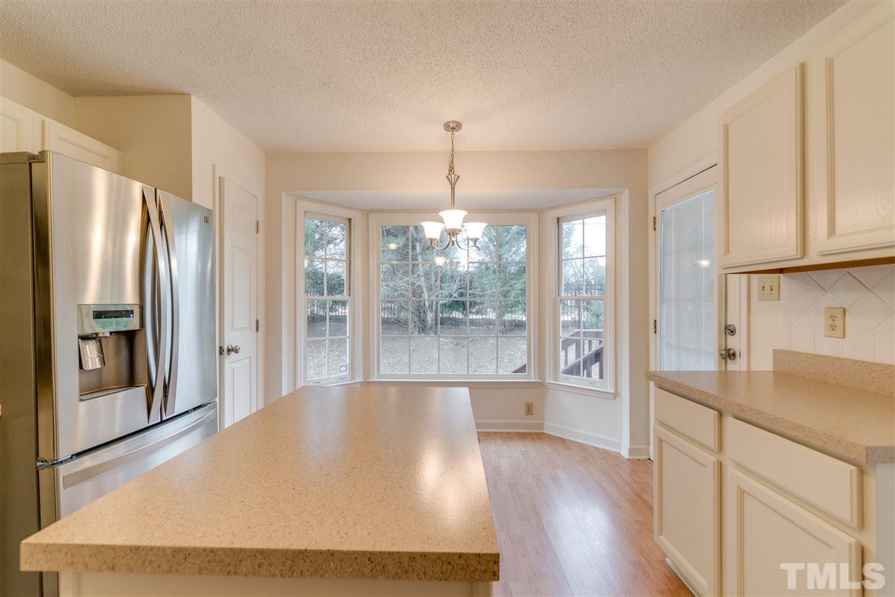 4213 Knightsbridge Way Raleigh, NC 27604 - Photo 10 of 23 a large kitchen with kitchen island a large window a refrigerator and stainless steel appliances