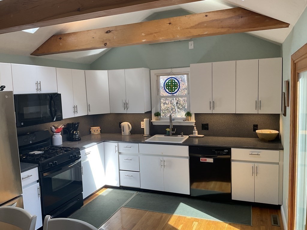 18 Ridgeway Street Dedham, MA 02026 - Photo 9 of 24 a kitchen with a sink dishwasher and a stove top oven with wooden cabinets