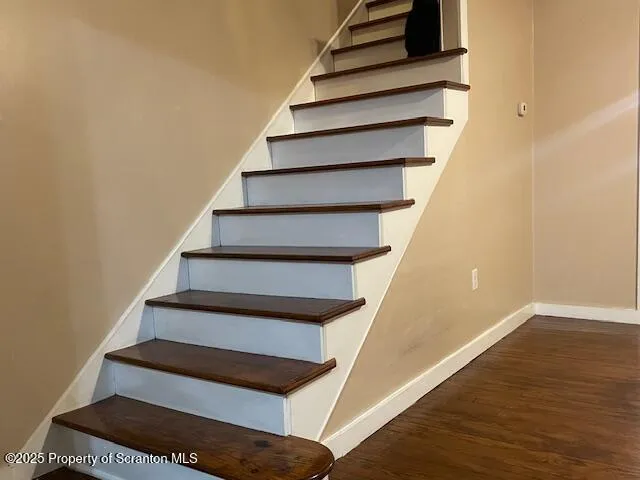 a view of staircase with railing and white walls