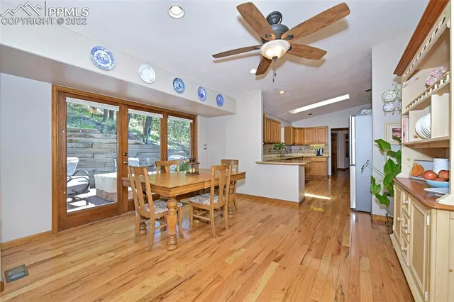 a dining room with furniture a large window and wooden floor