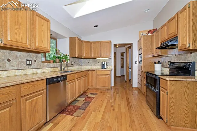 a kitchen with a sink a counter top space stainless steel appliances and a window