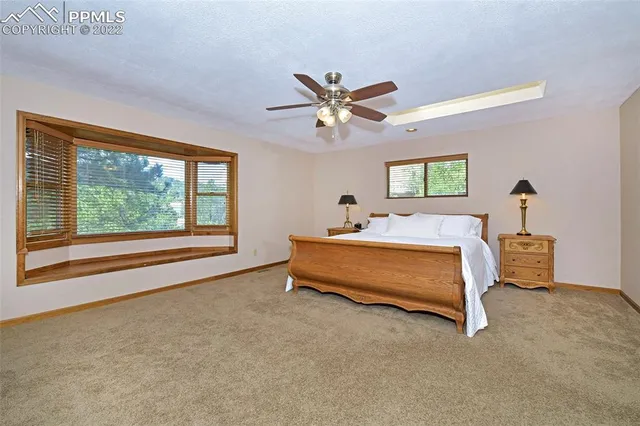 a bedroom with a bed and a large window