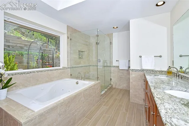 a spacious bathroom with a granite countertop tub next to a large window
