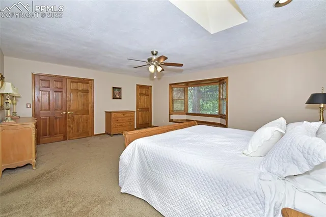 a bedroom with a large bed a chandelier and dresser