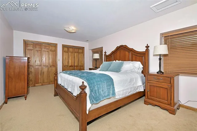a spacious bedroom with a bed and a dresser